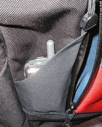 outside pockets just under the flap, flap raised, with a phone for scale